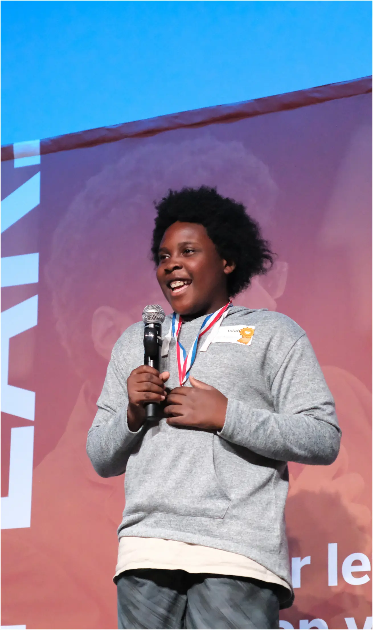 smiling young man stands with a microphone